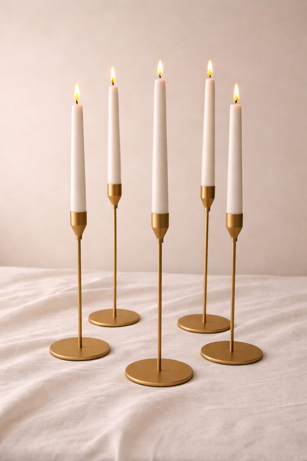 Castiçais de latão com velas tipo taper brancas