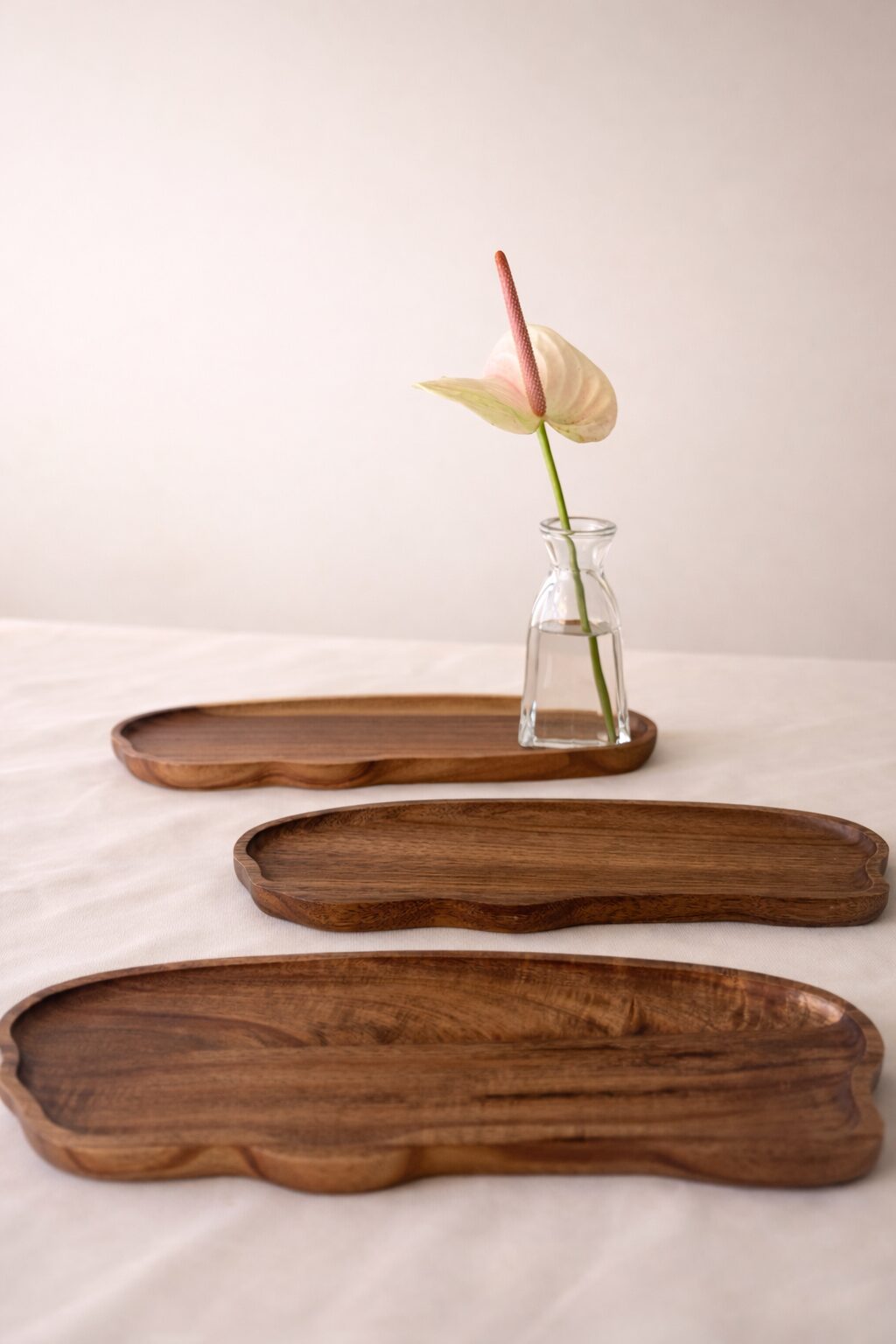 Travessas orgânicas de madeira com vaso de vidro e antúrio blush